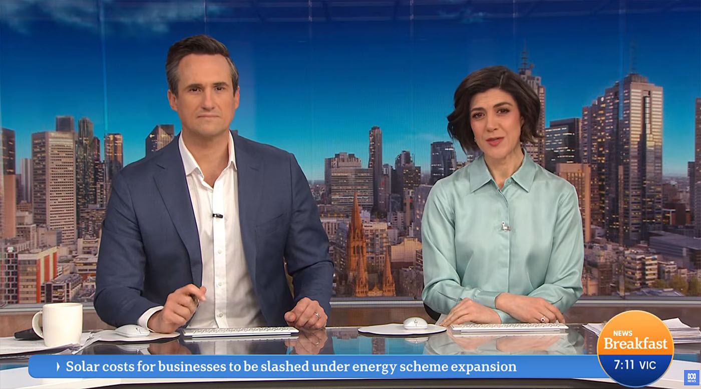 Shot of two presenters sat in the desk area of the ABC Breakfast studio. The digital backdrops we created are displayed on the large format LED screens located behind the desk