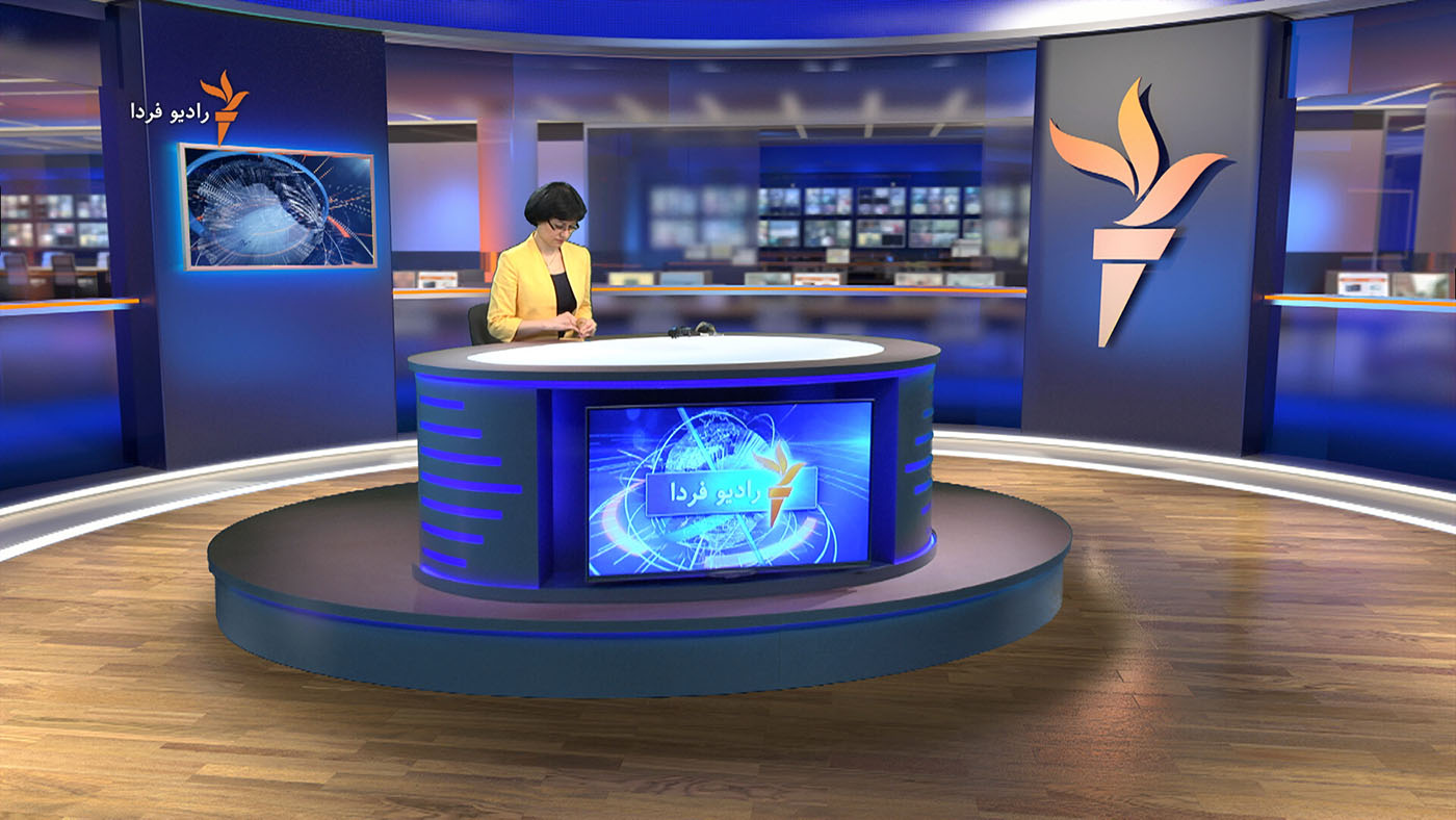 A female newsreader sits at a physical desk within a greenscreen studio, but in place of the greenscreen we see a virtual studio and newsroom scene, achieved using the Tricaster system