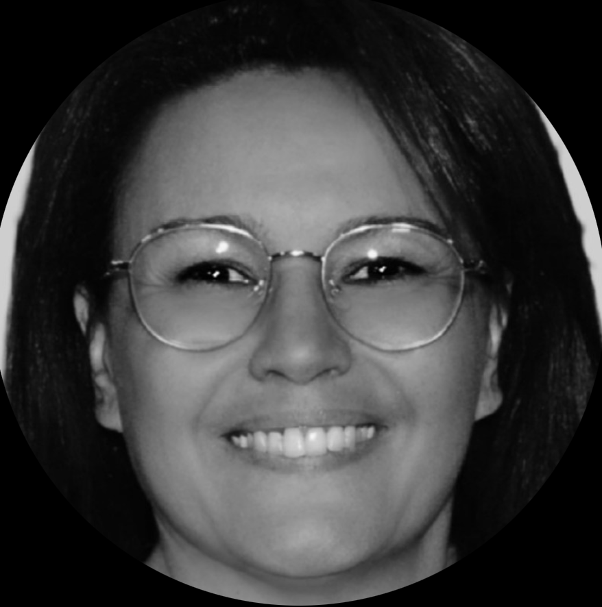 Close-up black and white portrait of a smiling woman wearing round glasses.