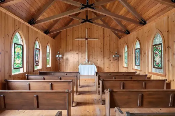 Wedding chapel with wooden walls and ceilings, stained glass windows, and wood pews in Anacortes, WA.