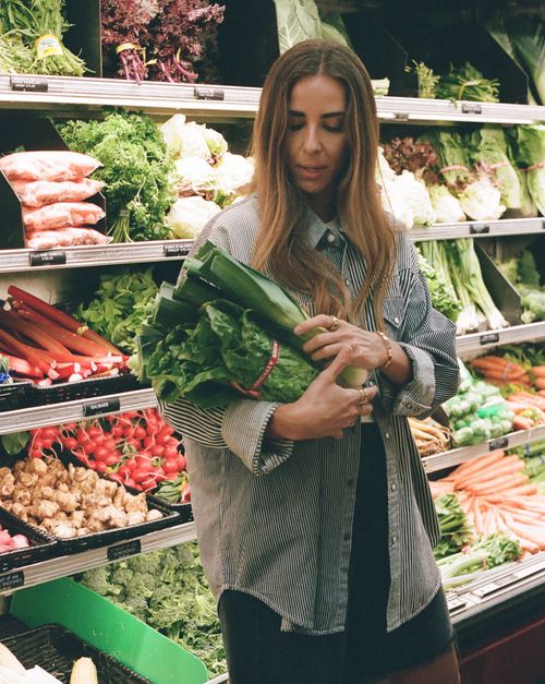Fruits and vegetables and a bottle of water on a turqouise background