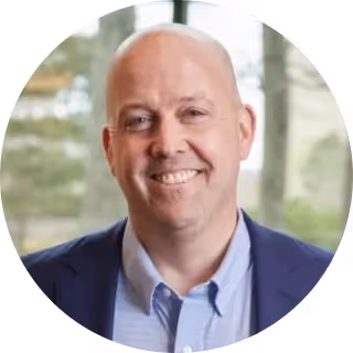 A man with a bald head and a blue shirt. - Wellinks Images