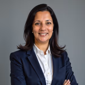 A woman wearing a blue suit and white shirt smiles for the camera. - Wellinks Images