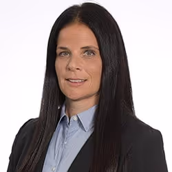 A woman with long black hair wearing a blue shirt and black jacket. - Wellinks Images