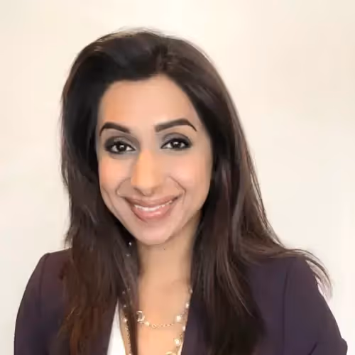 A woman wearing a black suit and a gold necklace.