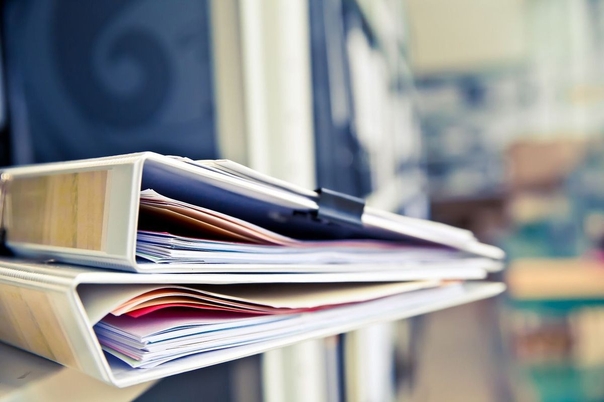 Pile of documents with Black clips in folders stack up.