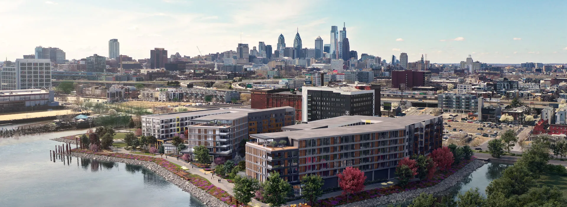 3D rendering of Festival Pier development in Philadelphia, showing an aerial perspective of modern buildings surrounded by a riverbank park, with the city skyline in the background.