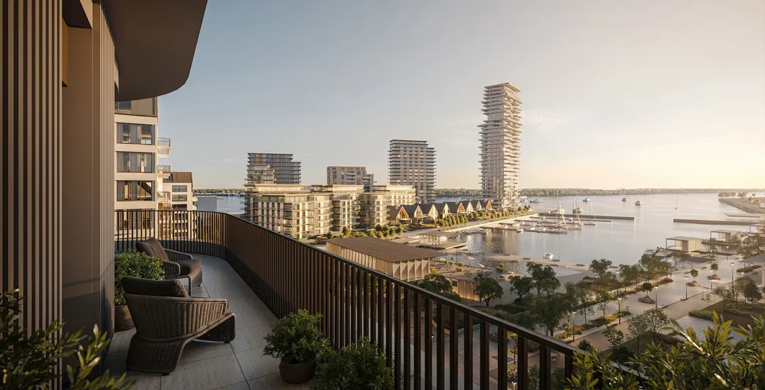 Sunset view from a balcony overlooking a vibrant waterfront district with multiple high-rises and marina docks – featured in a high-end construction project portfolio.
