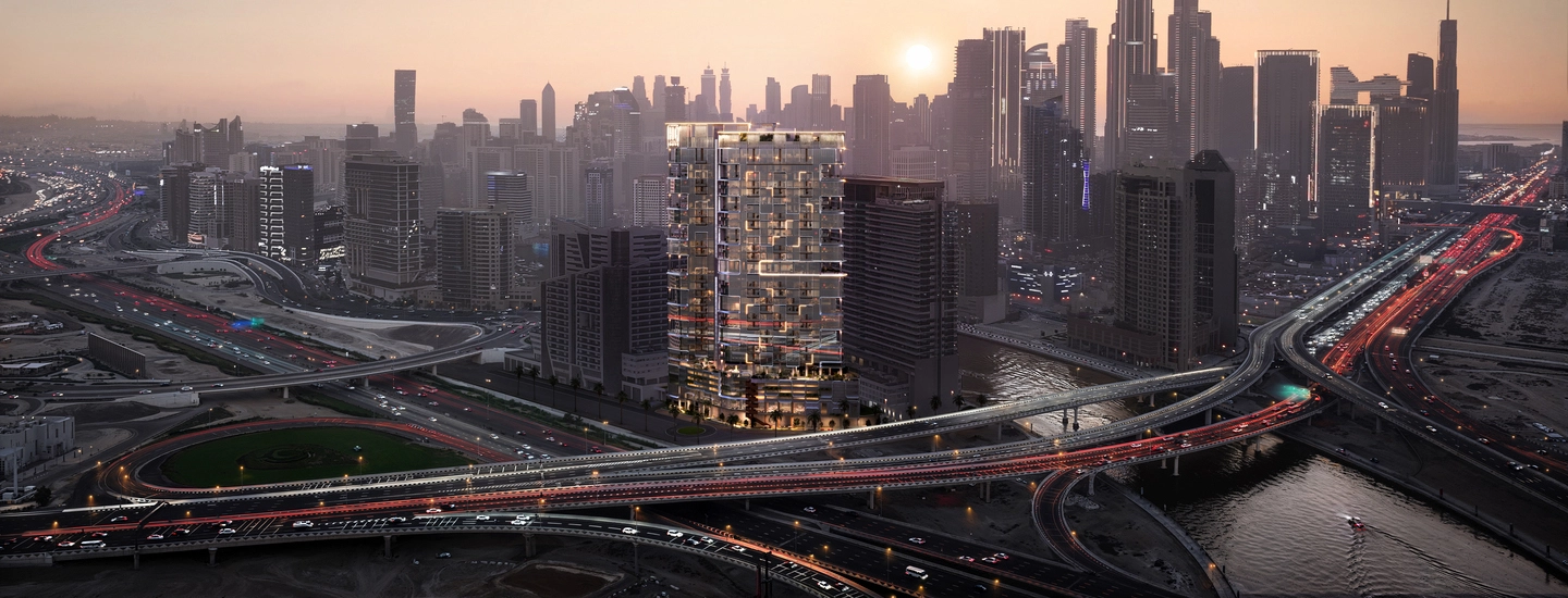 Illuminated luxury tower surrounded by highways and skyline views at sunset, representing large-scale urban investments for building a real estate portfolio.