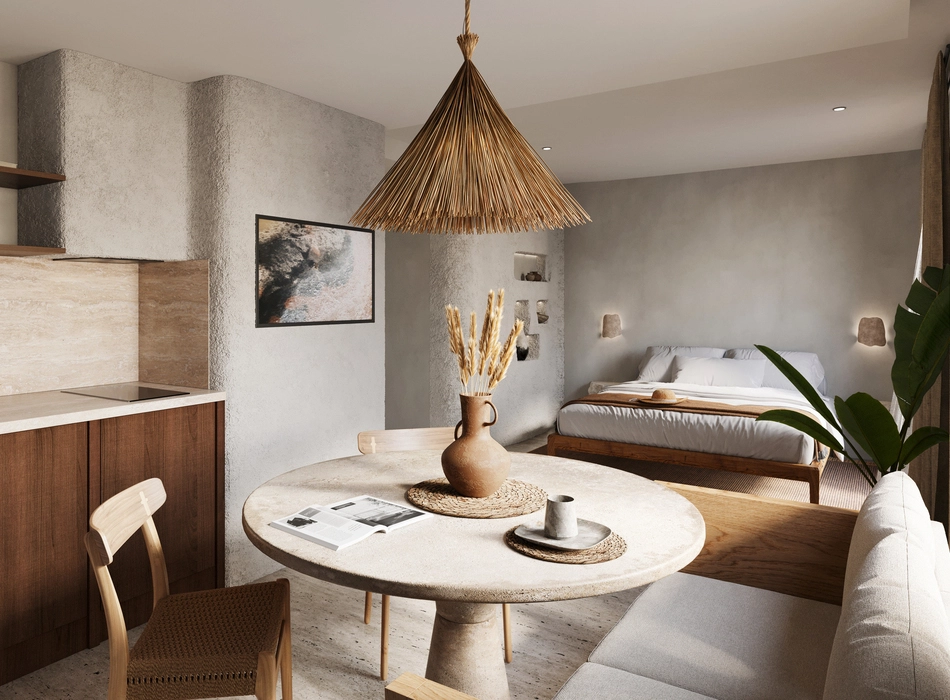 Open-plan boutique hotel studio with dining table, kitchen area, and textured walls highlighting modern hospitality design interior.