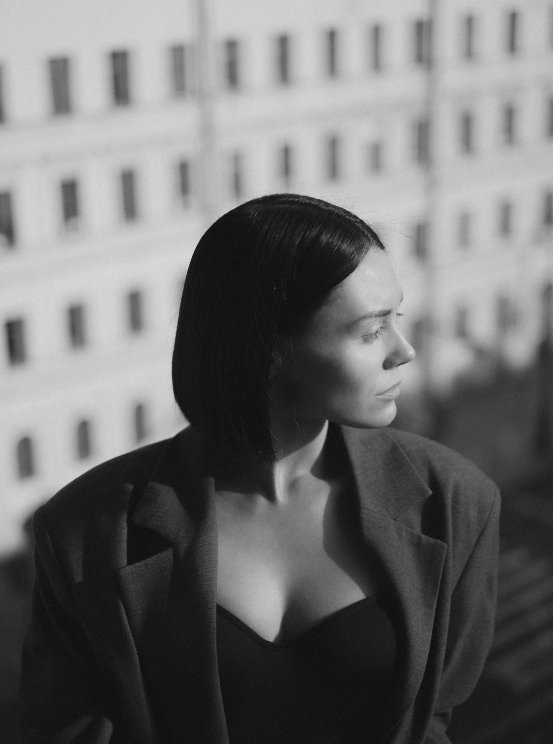 Black and white portrait of a woman with short hair in a blazer looking to the right.