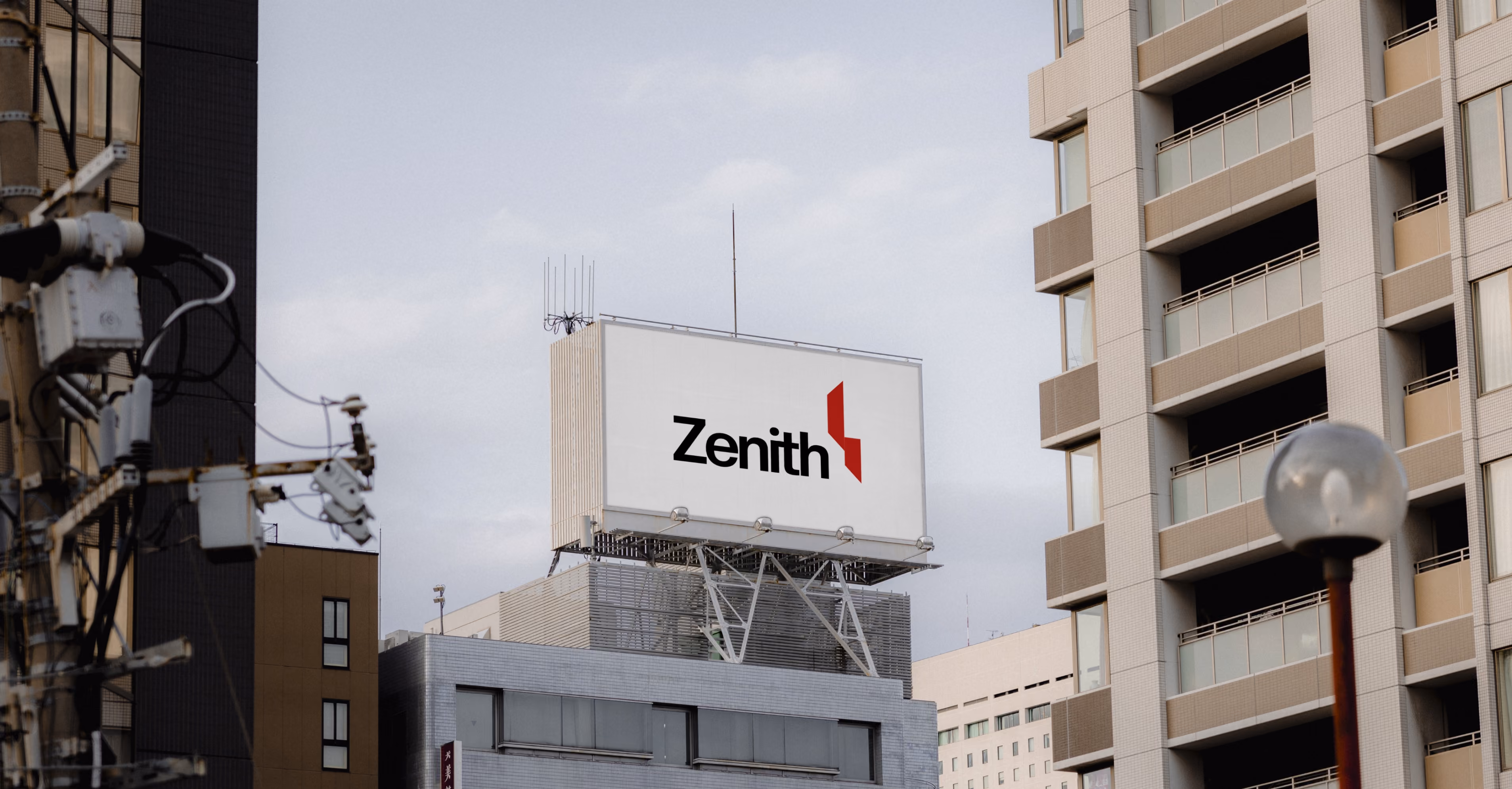 Billboard on a rooftop with the word 'Zenith' and a red geometric logo on it in a cityscape.