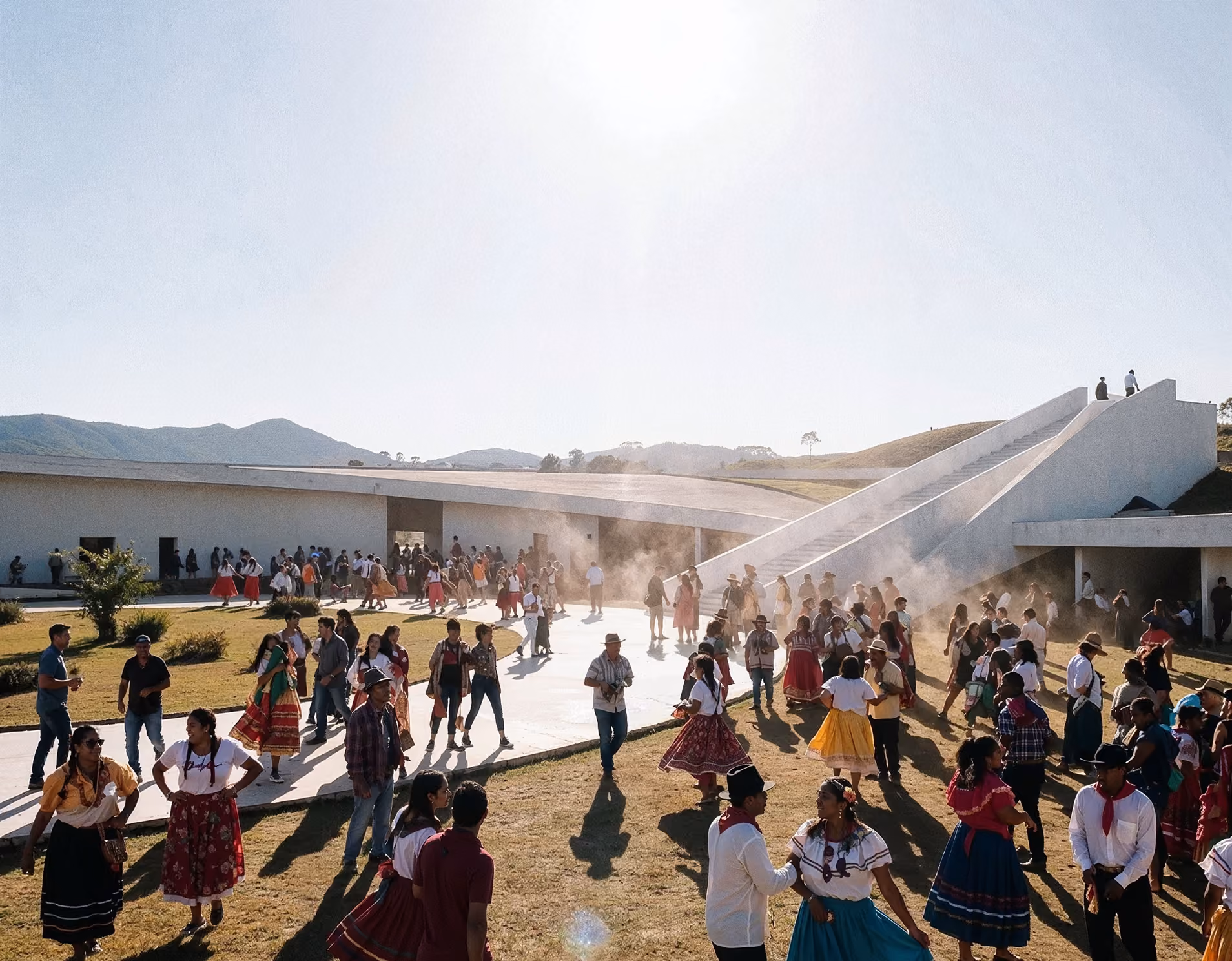 Crowd of people, many in traditional colorful clothing, gathered outdoors near modern white building with ramp.