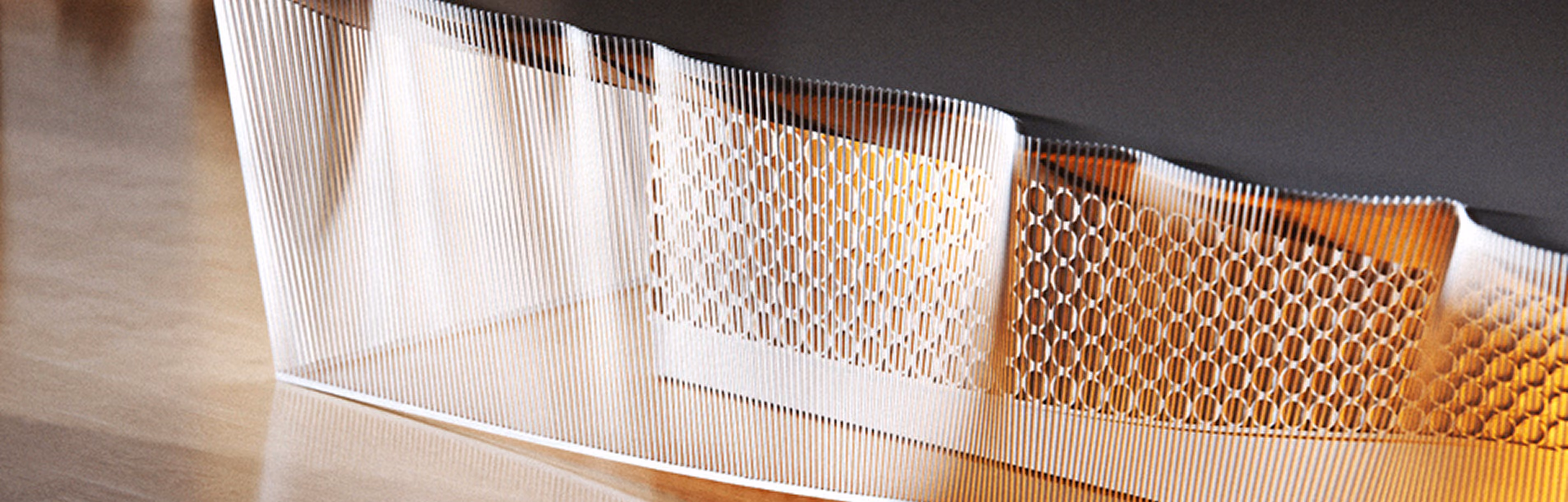 Close-up of a translucent sculpture with vertical lines and circular patterns on a reflective surface.