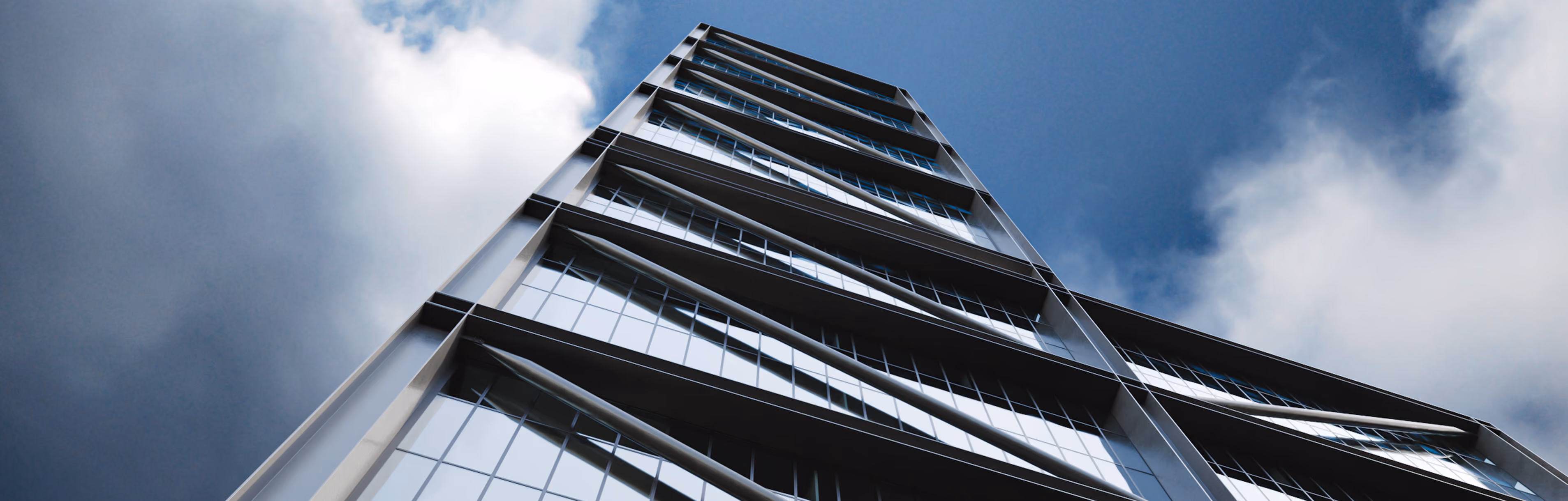 Upward view of a modern glass commercial building against a partly cloudy blue sky.