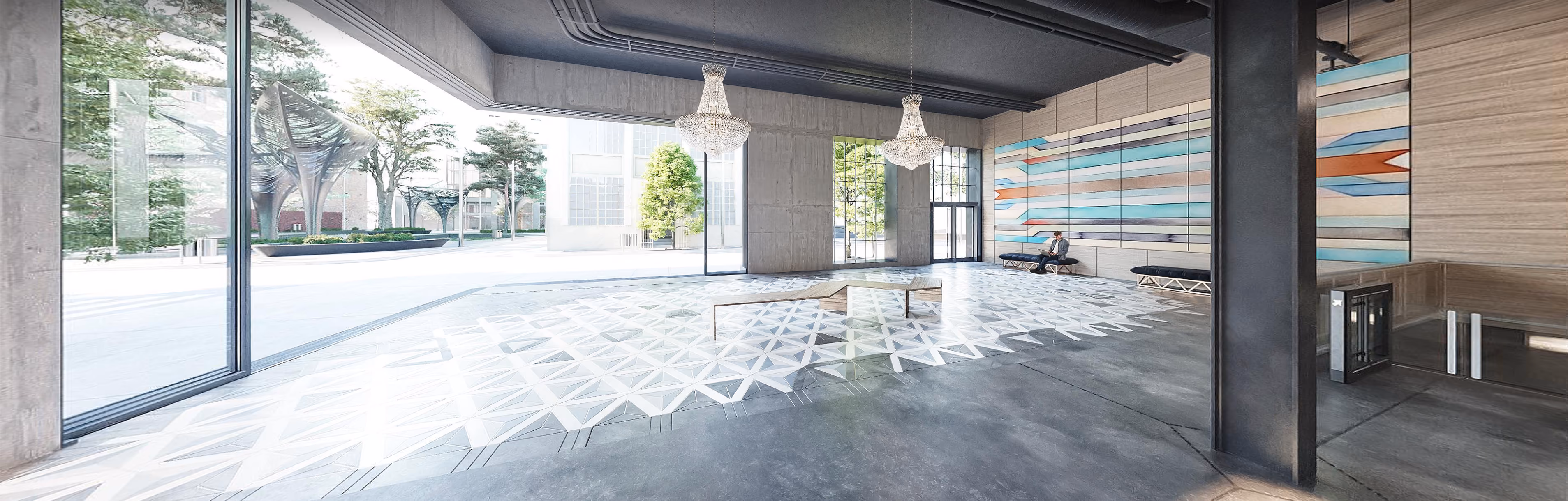 Modern lobby with large windows, geometric floor tiles, chandeliers, wall art, and a man seated on a bench.
