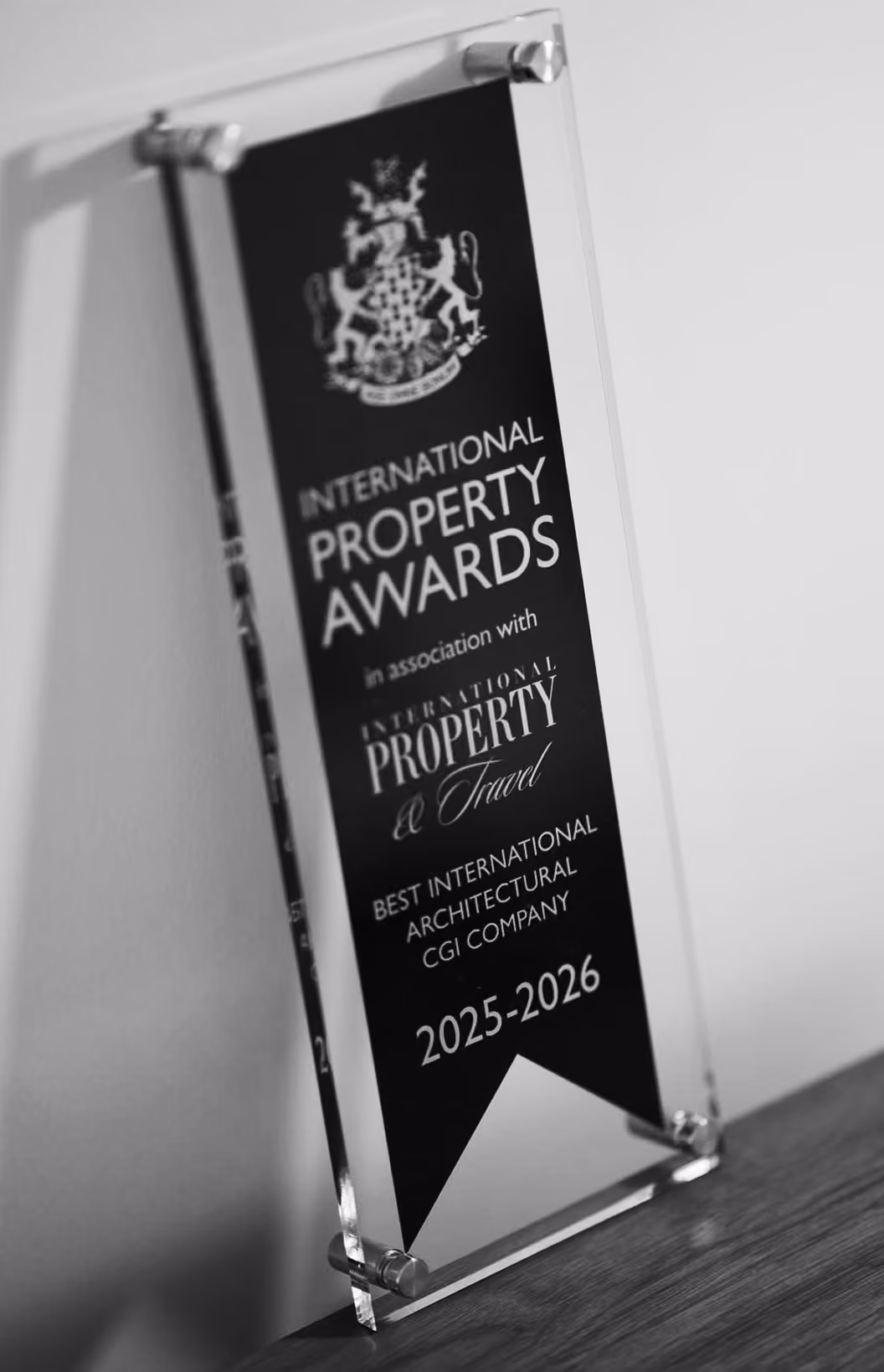 Glass award plaque with a black ribbon inside that reads: International Property Awards in association with International Property & Travel, Best International Architectural CGI Company, 2025-2026.