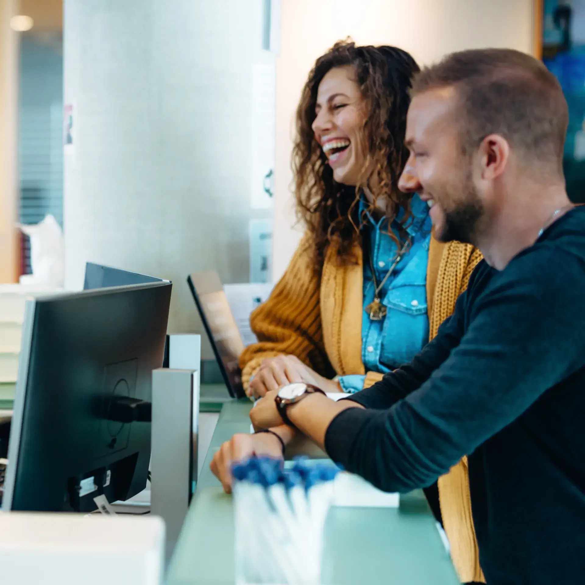 A man and a woman sitting at a computer.