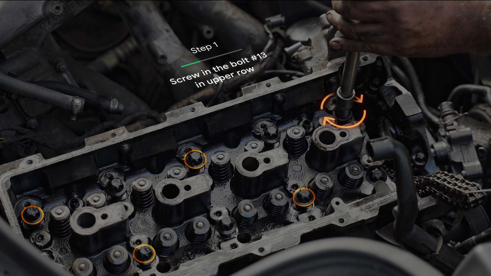 Inside a car engine, an orange augmented reality visual simulates a twisting motion, prompting a person to turn a tool.