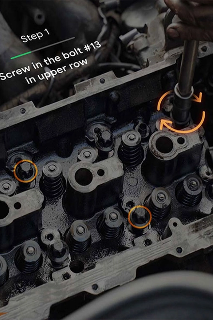 A link card element: Inside a car engine, an orange augmented reality visual simulates a twisting motion, prompting a person to turn a tool.