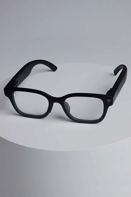 A link card element: A pair of stylish black AR glasses rests on a display pedestal.