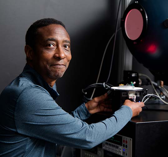 A Magic Leap technician prepares to insert a component test bed into a large spherical testing chamber.