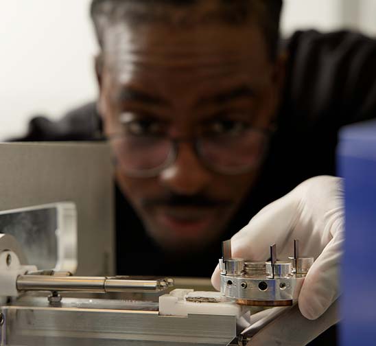 A Magic Leap technician carefully adjusts a component cradle within a machine.