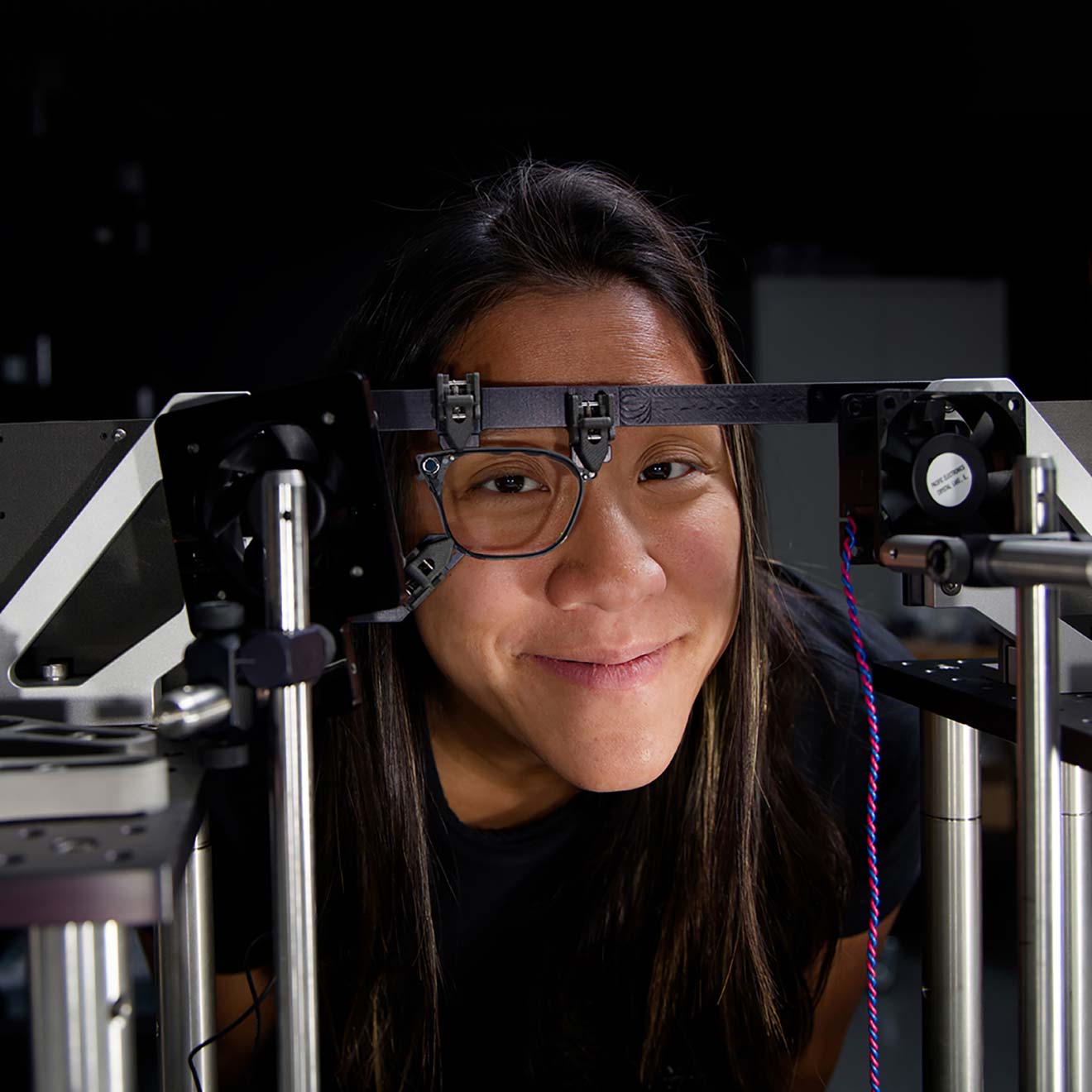 A Magic Leap engineer peers through a waveguide, mounted into a test bench frame, during a testing procedure.