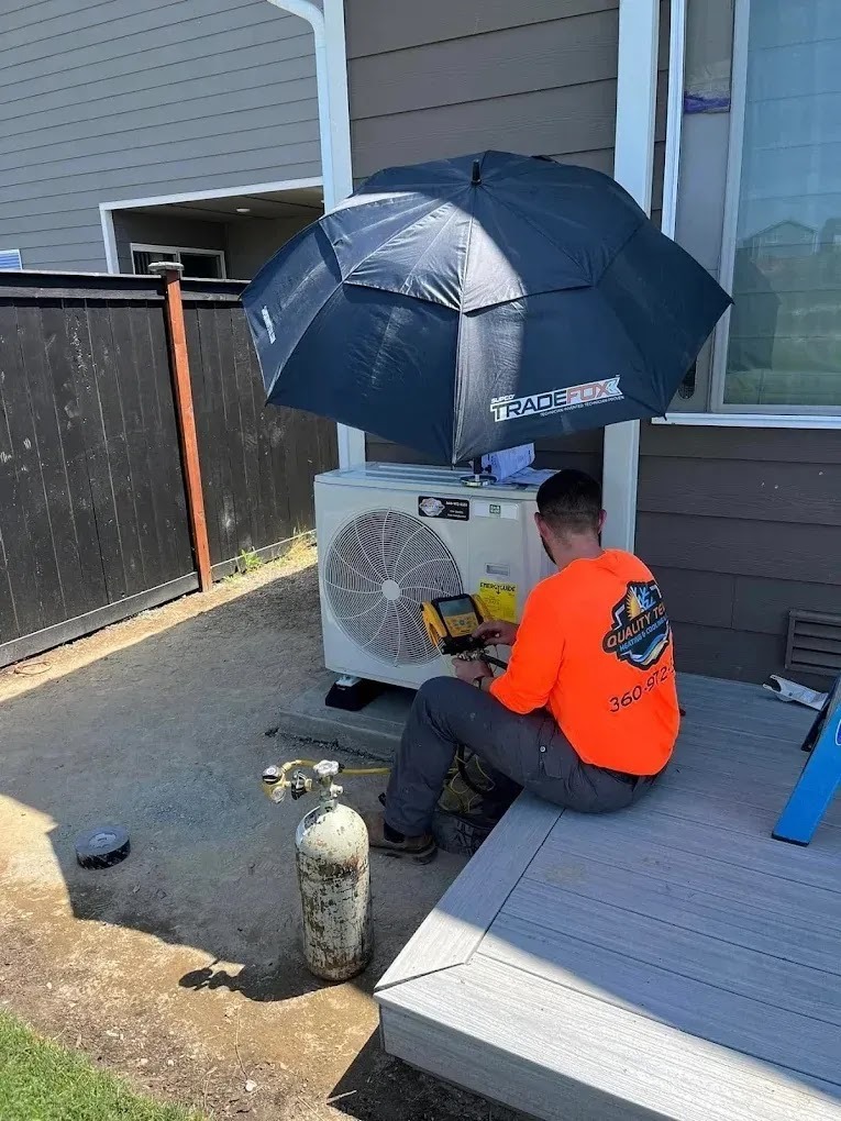 Technician performing spring maintenance on an air conditioning unit in a sunny backyard