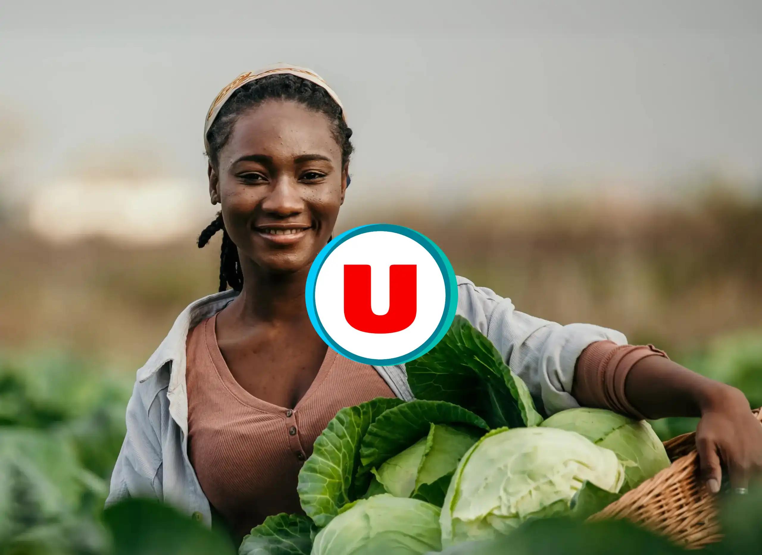 Femme souriante dans un champ avec panier de légumes frais et logo Magasins U Guadeloupe pour le site magasins-u.gp