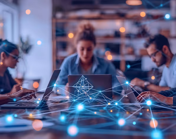 Group of people working on laptops with abstract glowing network connections overlay.