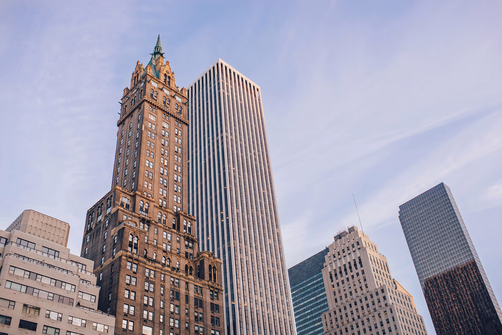 A stunning skyscraper towers against a clear blue sky, featuring a sleek and modern design with reflective glass windows
