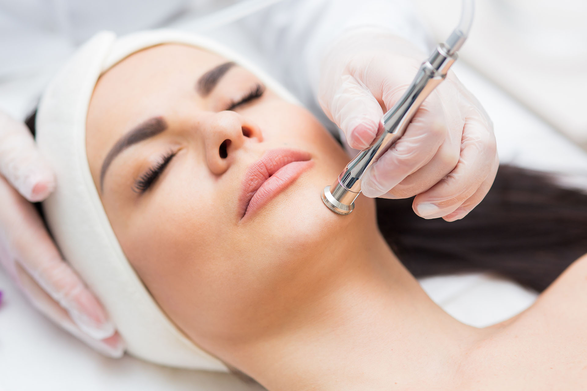 Woman receiving a diamond microdermabrasion treatment at a skin care clinic