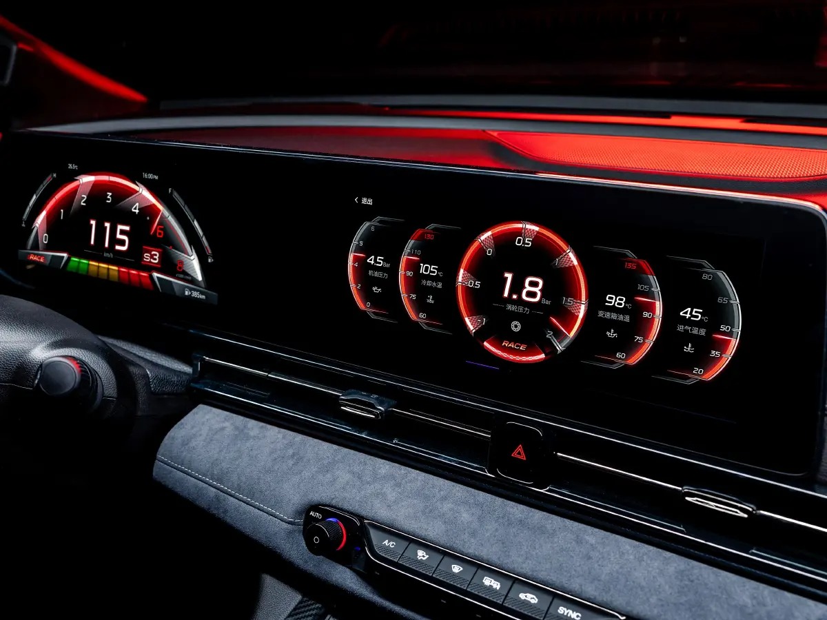 Tablero de instrumentos del automóvil con velocímetro digital que muestra 115 km/h y múltiples indicadores redondos iluminados con detalles en rojo que muestran varios parámetros del motor.