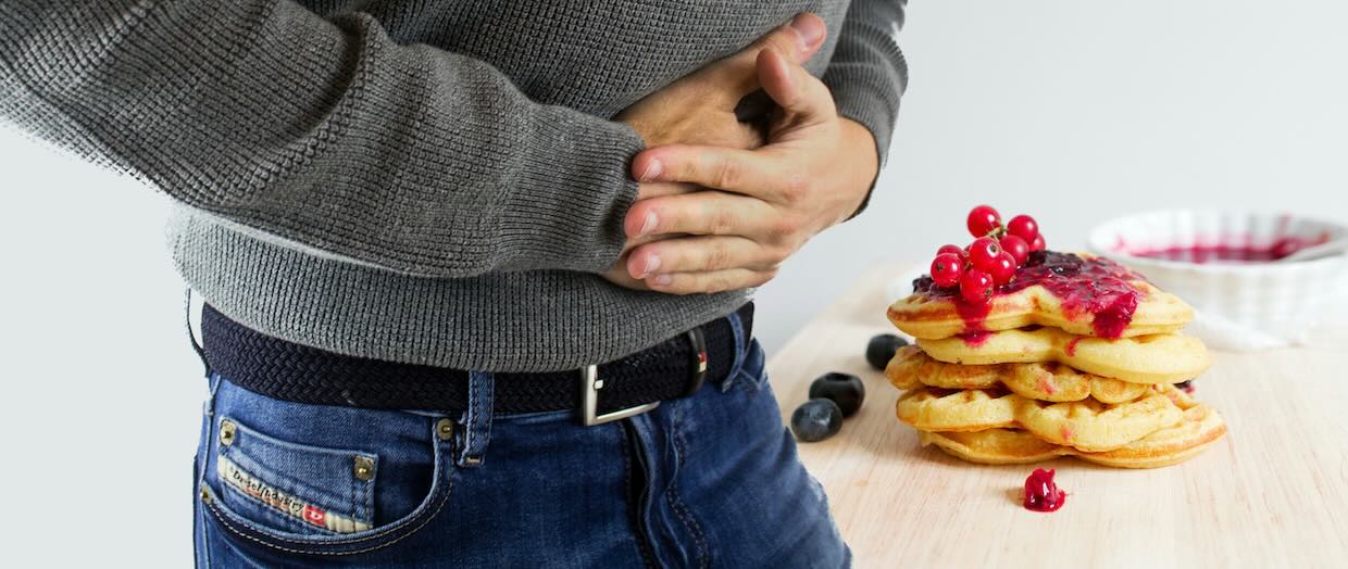 anonymous man holding stomach