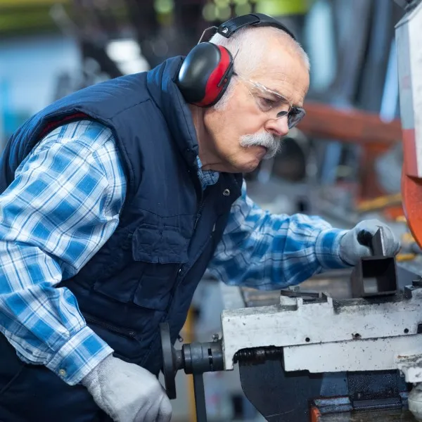 Welder with electronic earmuffs in a factory