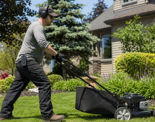Worker wearing Bluetooth ear protection for mowing woodworking and shop work