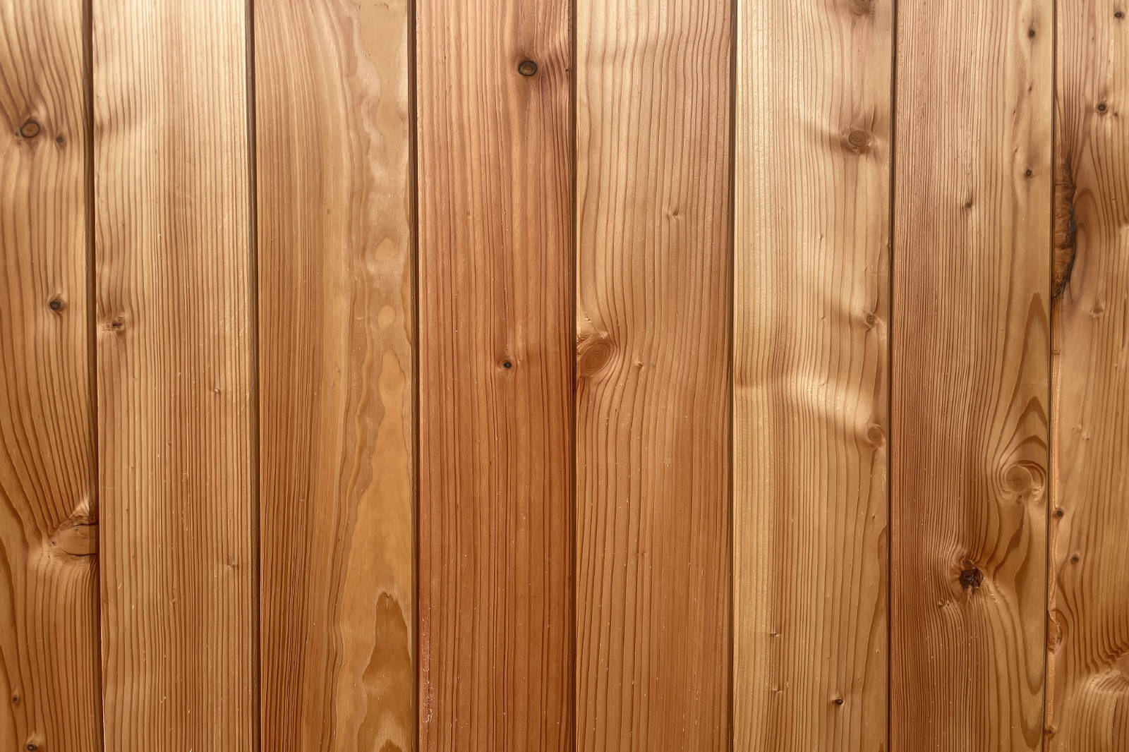 Close-up of smooth, vertical wooden planks with natural grain and knots.