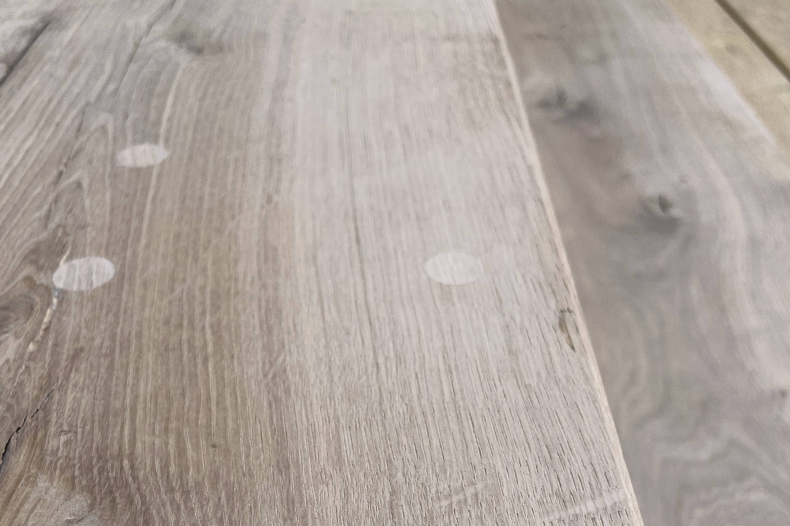 Close-up of light wooden boards with visible grain texture and circular wood plugs.