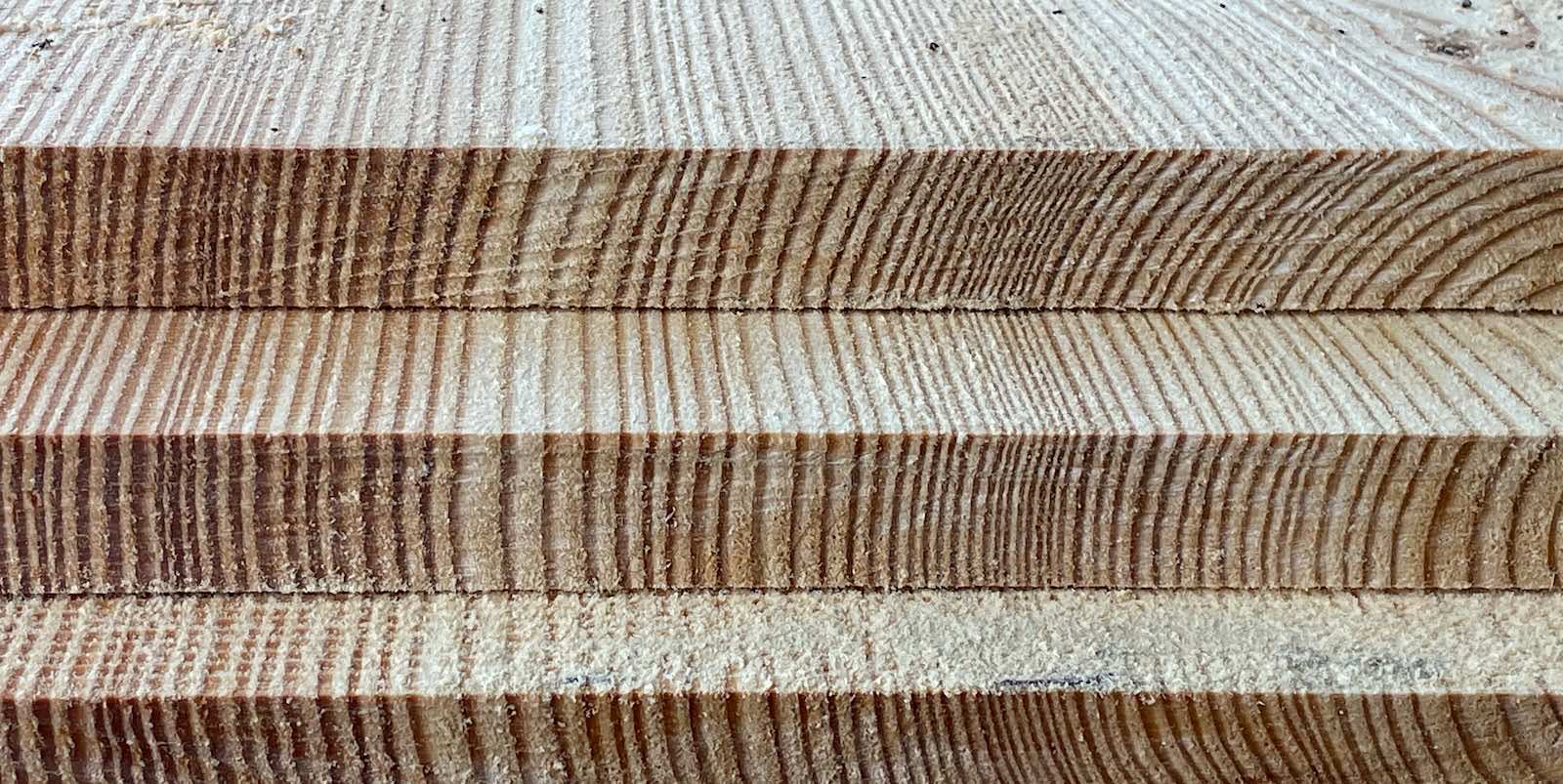 Close-up of stacked wooden planks showing grain patterns and textures.