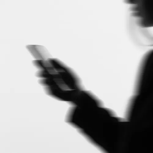 side profile in black and white of person holding a phone