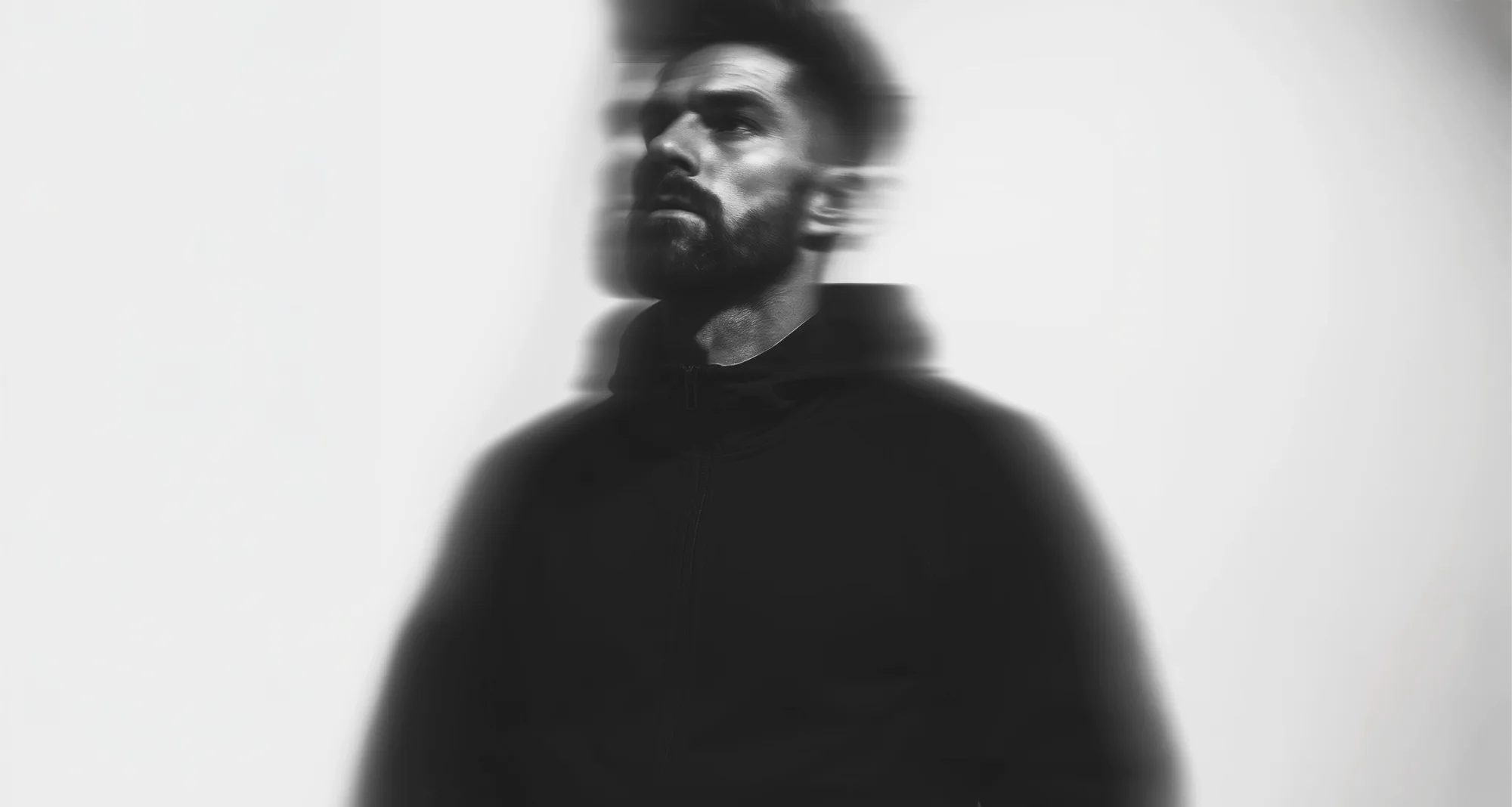 black and white profile of man looking up in hoodie