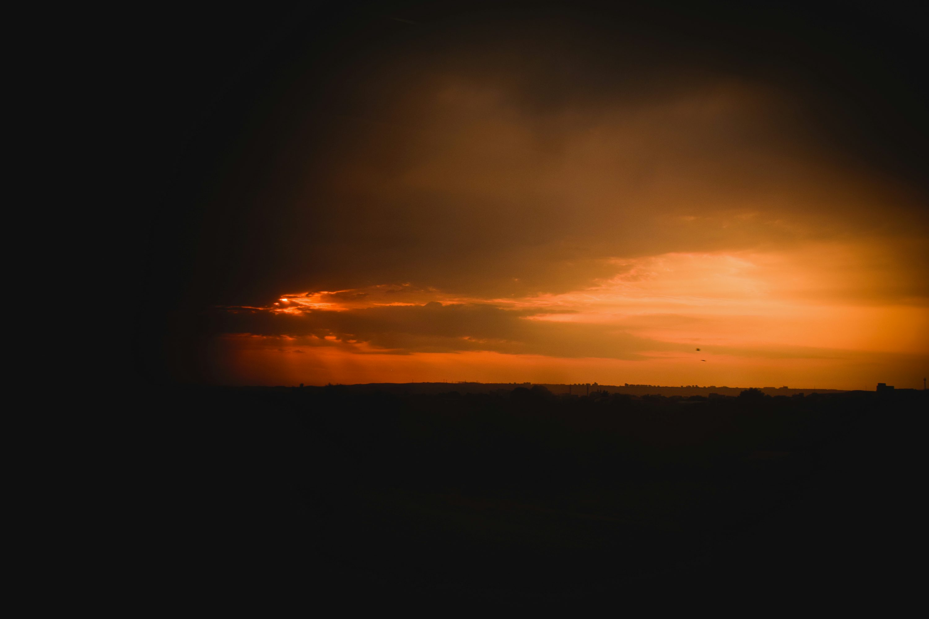 Dark clouds surround a beautiful, fiery sunset.