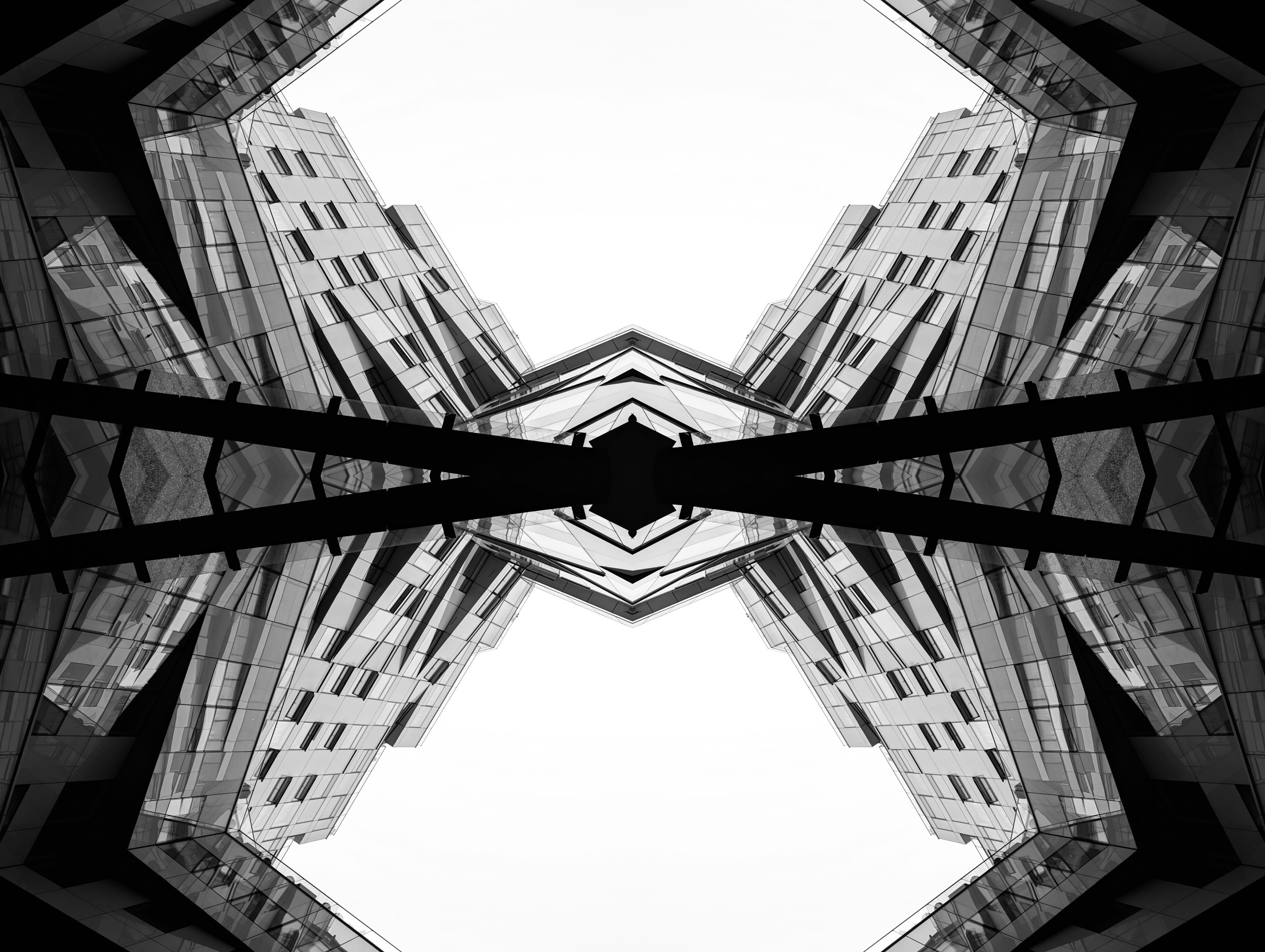 Symmetrical buildings against a bright sky.