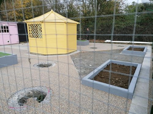 Cat enclosure showing the new resin bound aggregate flooring and raised bed filled with bark to act as litter tray for the cats.