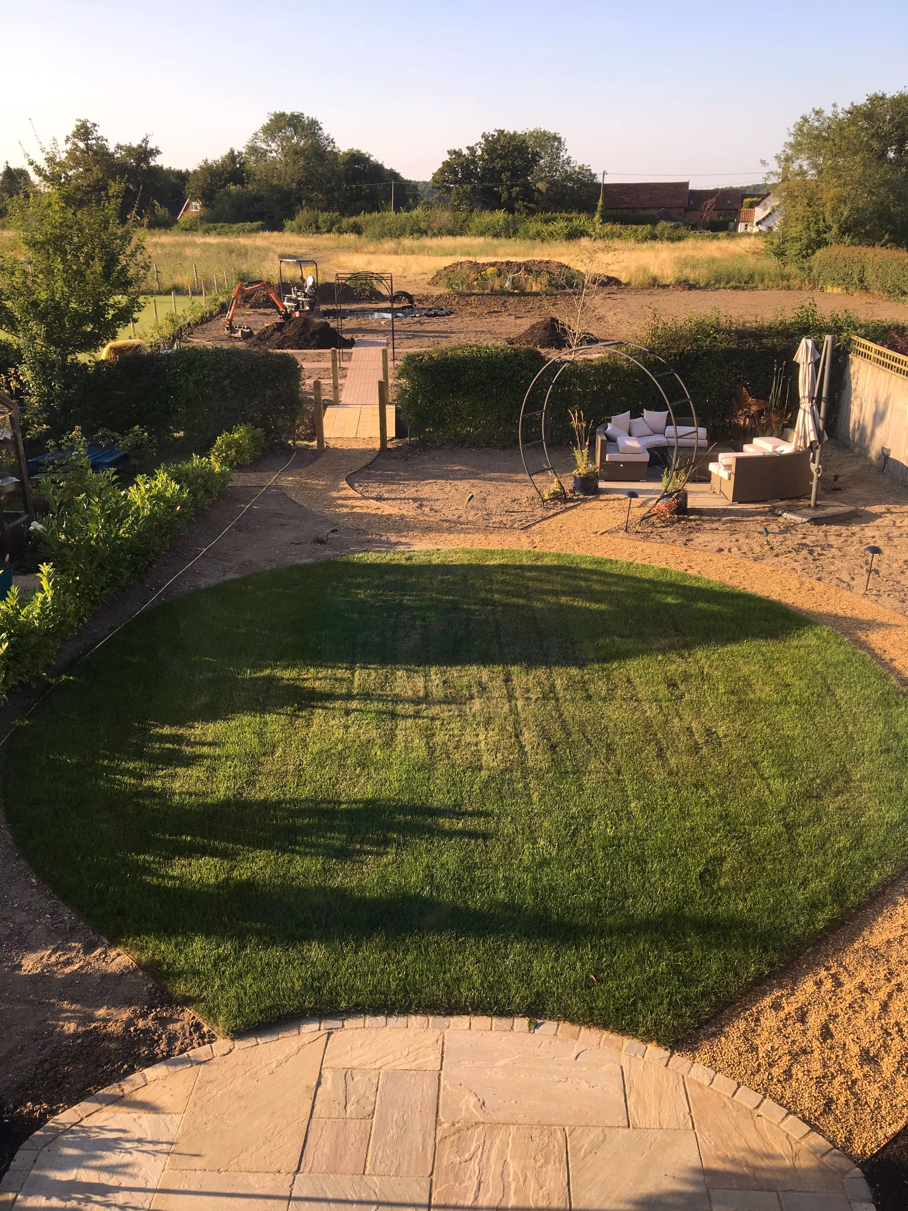 Back garden in the process of getting renovated. new look healthy lawn has been laid with the surrounding area under construction. A new patio curved patio area has also been laid at the front of the lawn.