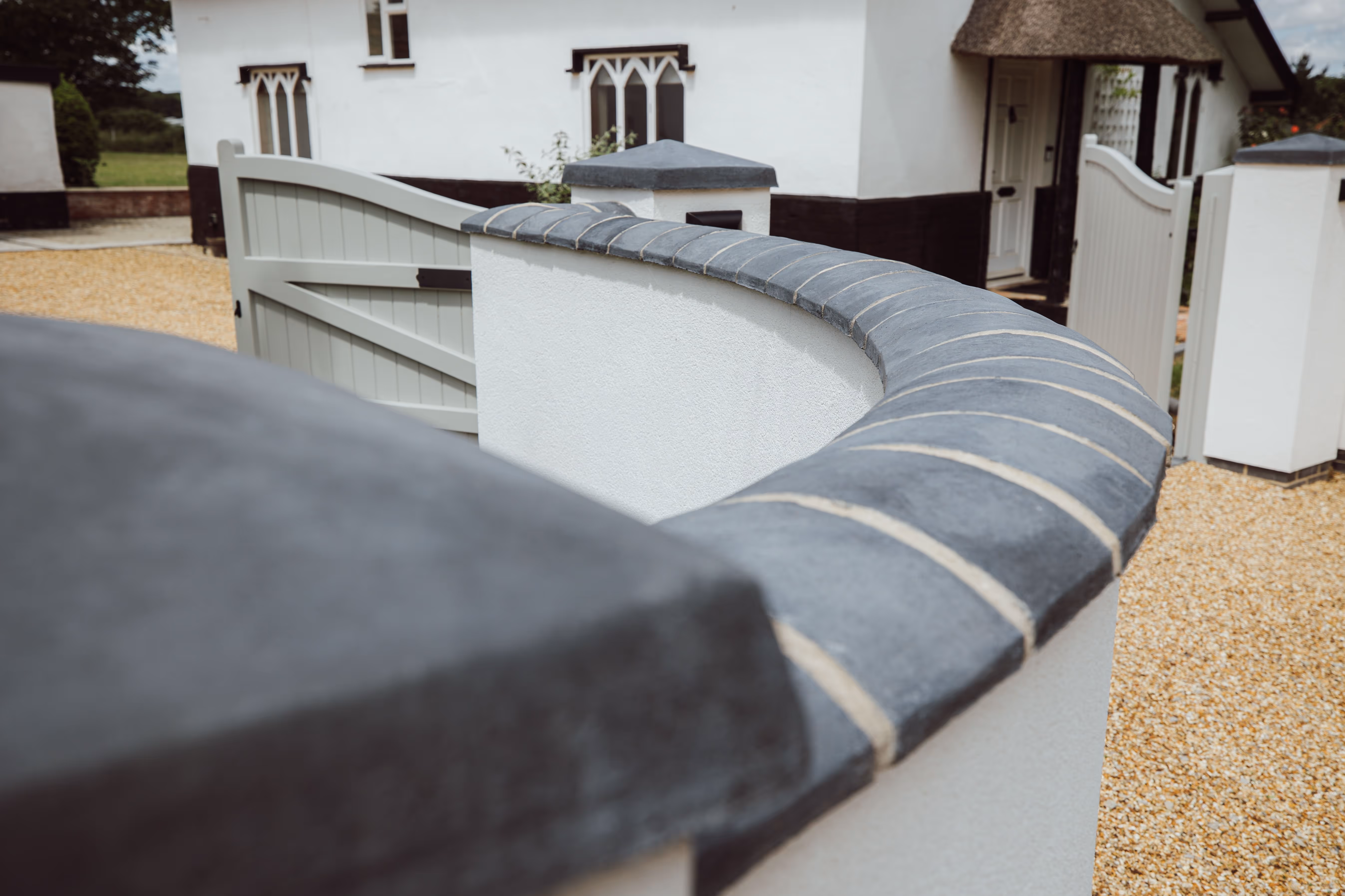 Close up image of the top of the rendered walls at Church Cottage showcasing the brick work on top of the walls.