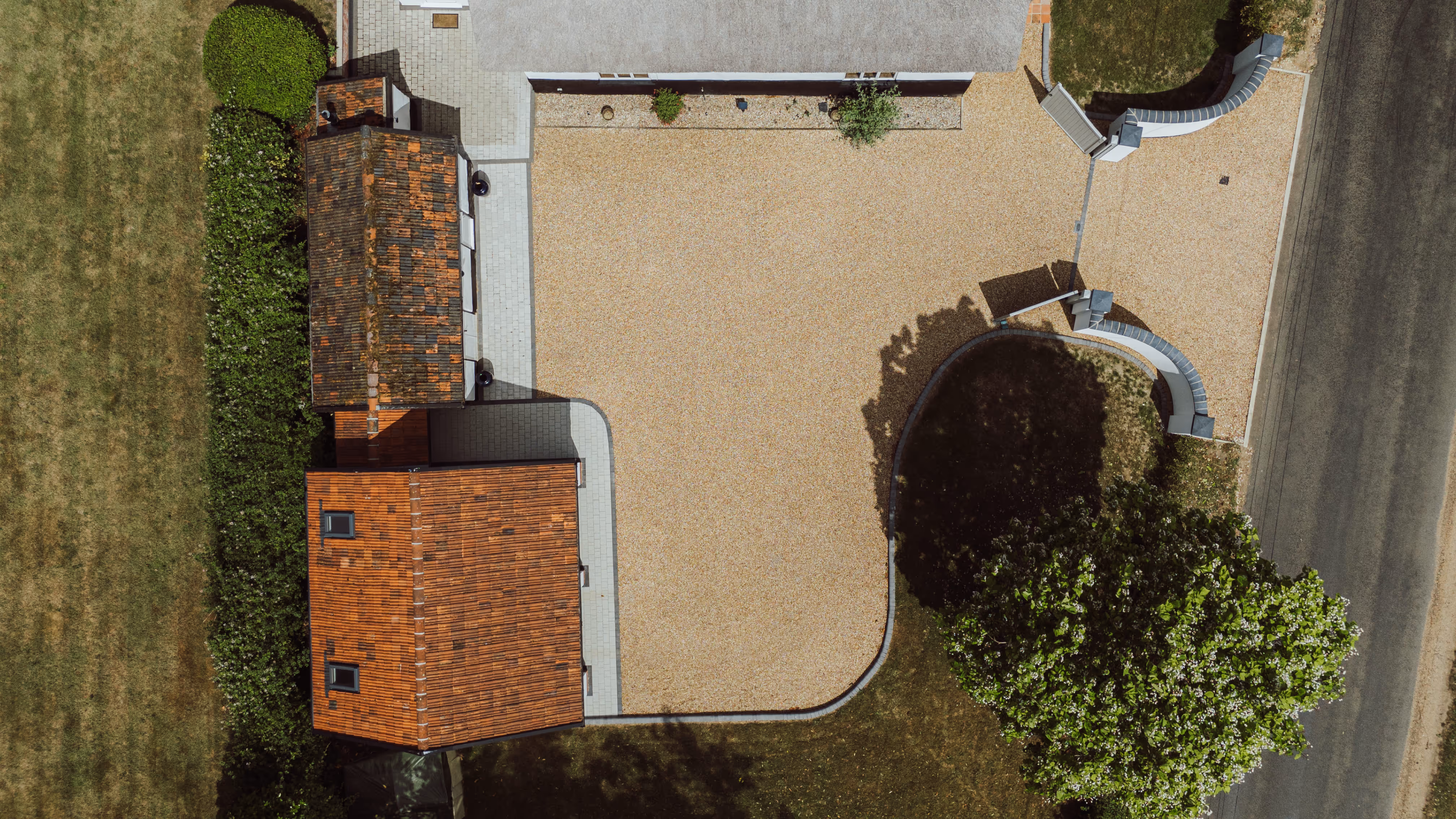 Top down view of Church. Cottage and its gravel driveway. 