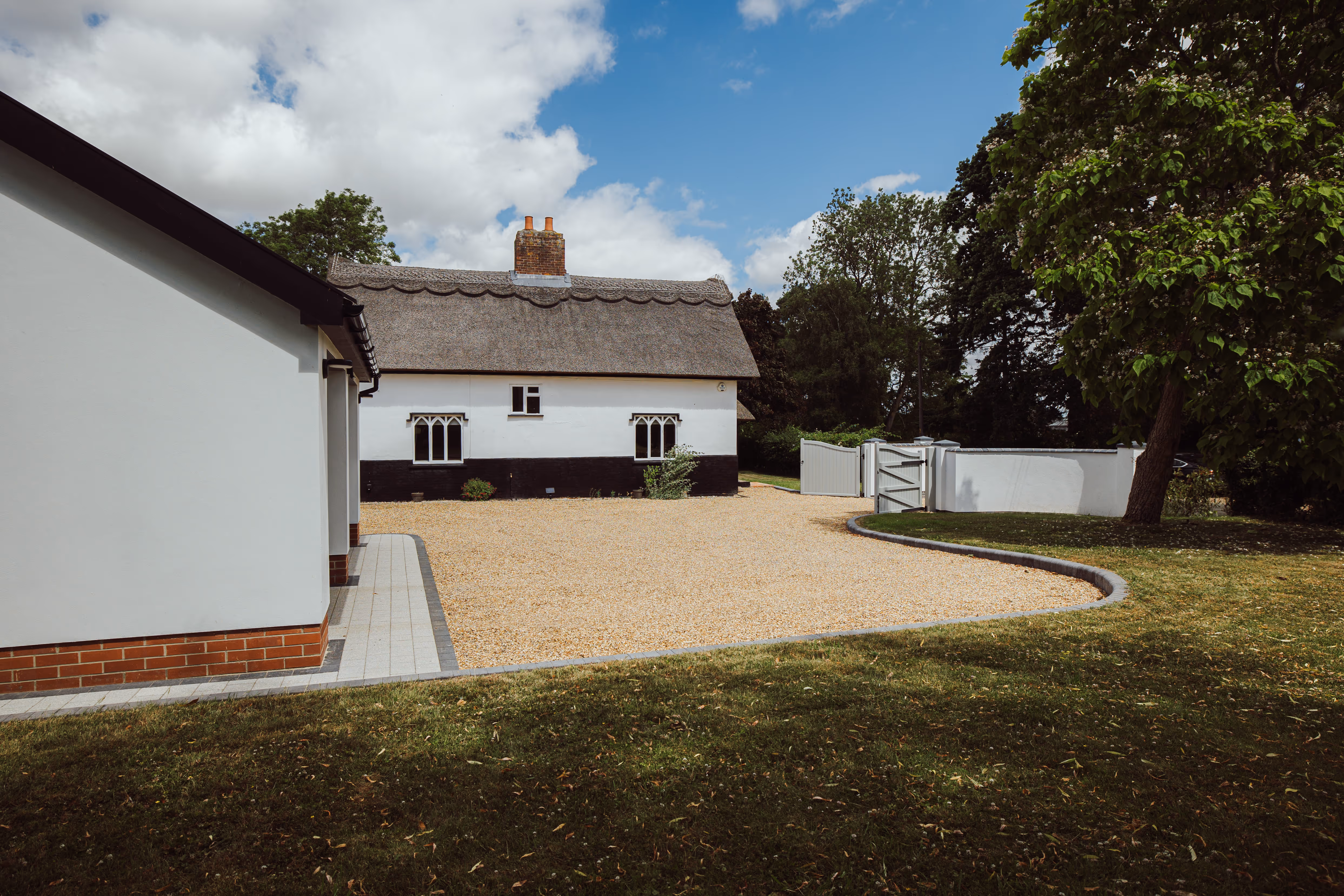 Zoomed out view from the side of Church Cottage, you can see the gravel driveway and block paving.
