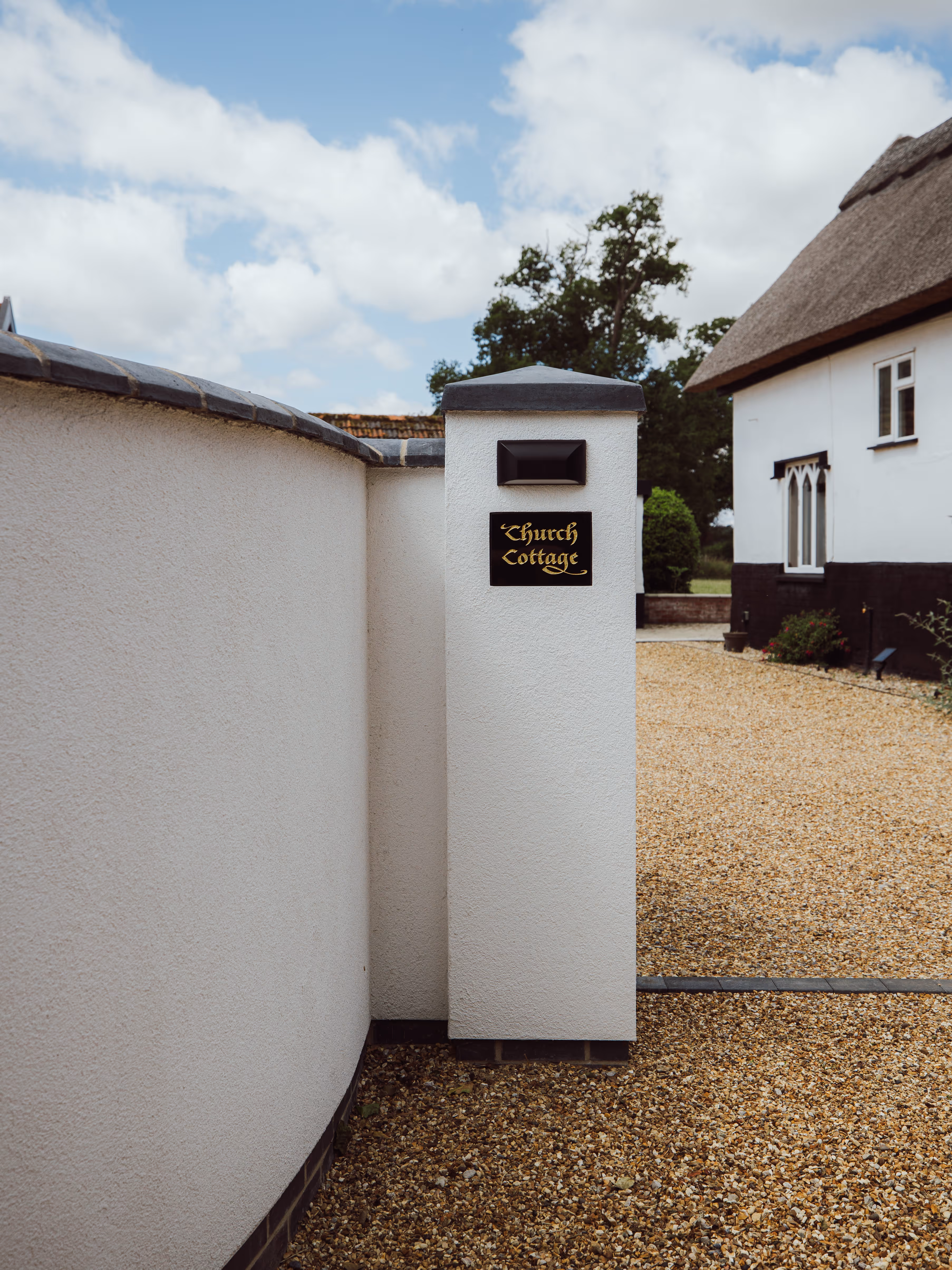 Rendered white walls and cottage sign built inti the render reading church cottage.